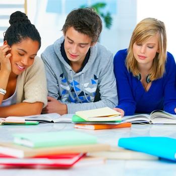 students sitting at a table looking at paperwork